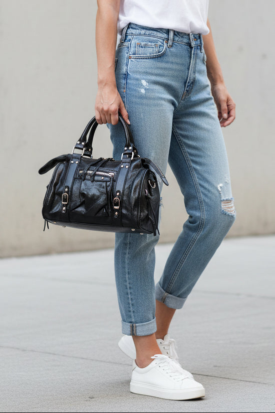Sac Azilal simili cuir brillant métallisé noir porté à la main — forme bowling, double poignée courte, bandoulière amovible, clous et boucles dorés, 28x20 cm — ineva
