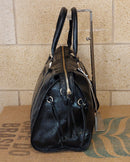 Grand Sac Bologne simili cuir brillant irisé noir vue de profil — 14 cm de profondeur, poche latérale zip avec franges, clous dorés — ineva

