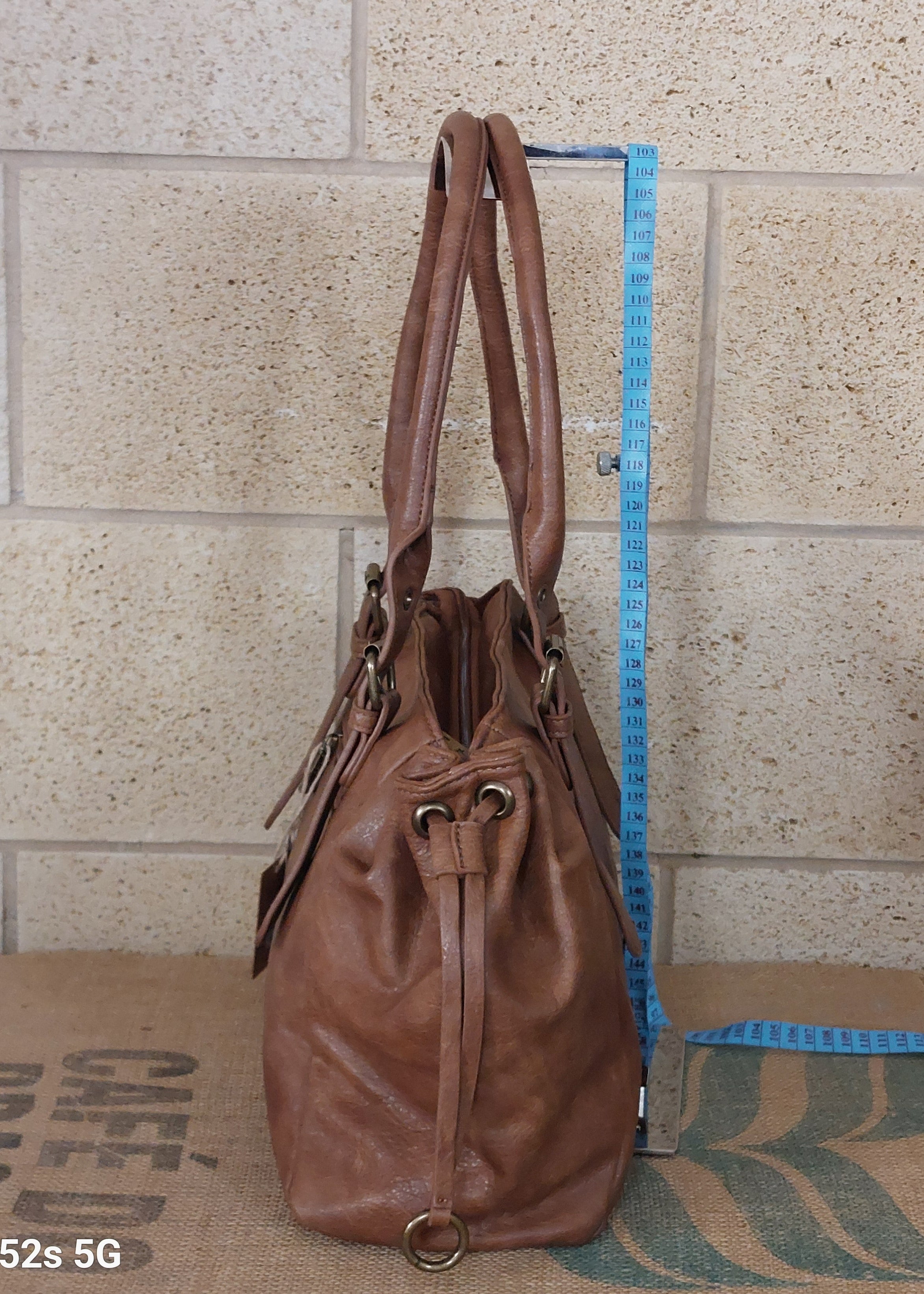 Sac Naples simili cuir vieilli camel vue de profil — côté froncé cordon coulissant œillets cuivrés, fermeture zip, double anse — ineva- carry le rouet
