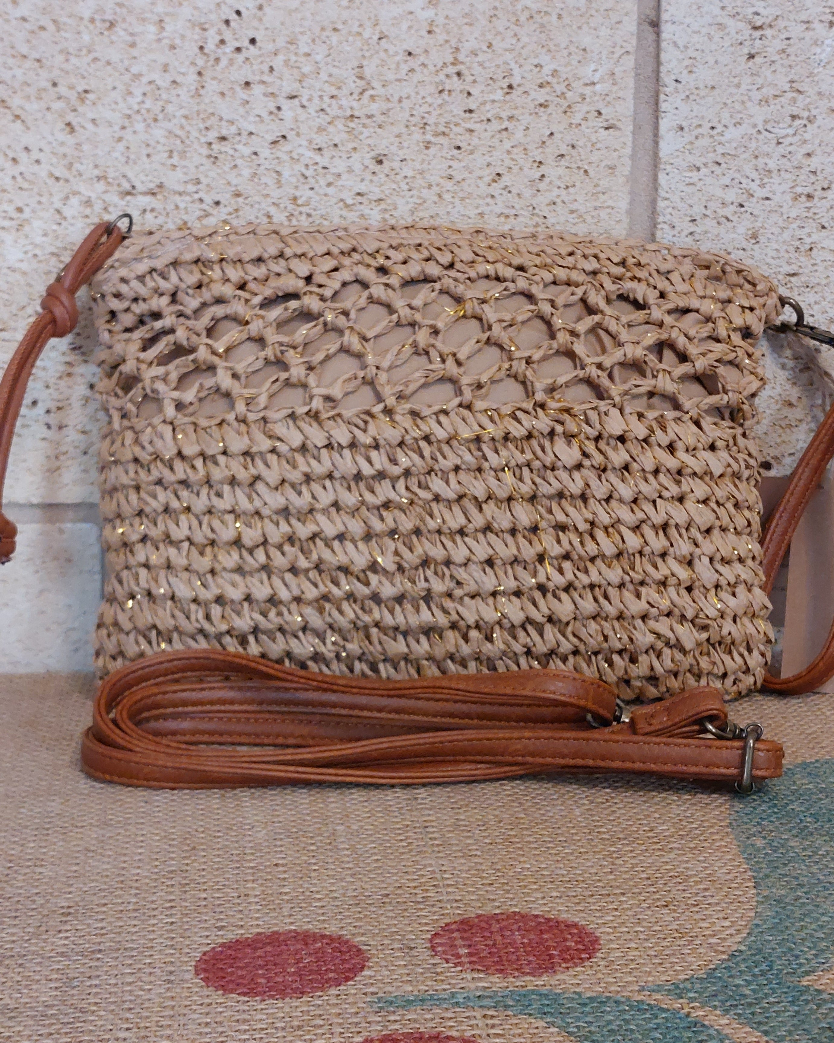 Pochette Porto raphia posée à plat – vue face et bandoulière simili cuir camel amovible, fermeture zip dorée

