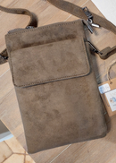 Sacoche téléphone Potello beige en suédine portée en bandoulière sur une tenue noire
