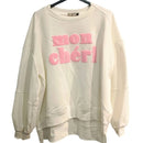 Sweat manches longues finis par un poigné a bord cotelé et  porté par un mannequin sur un jean. col rond et l'on voit devant une grosse incription MON CHERI en bouclette rose sur Sausset les pins