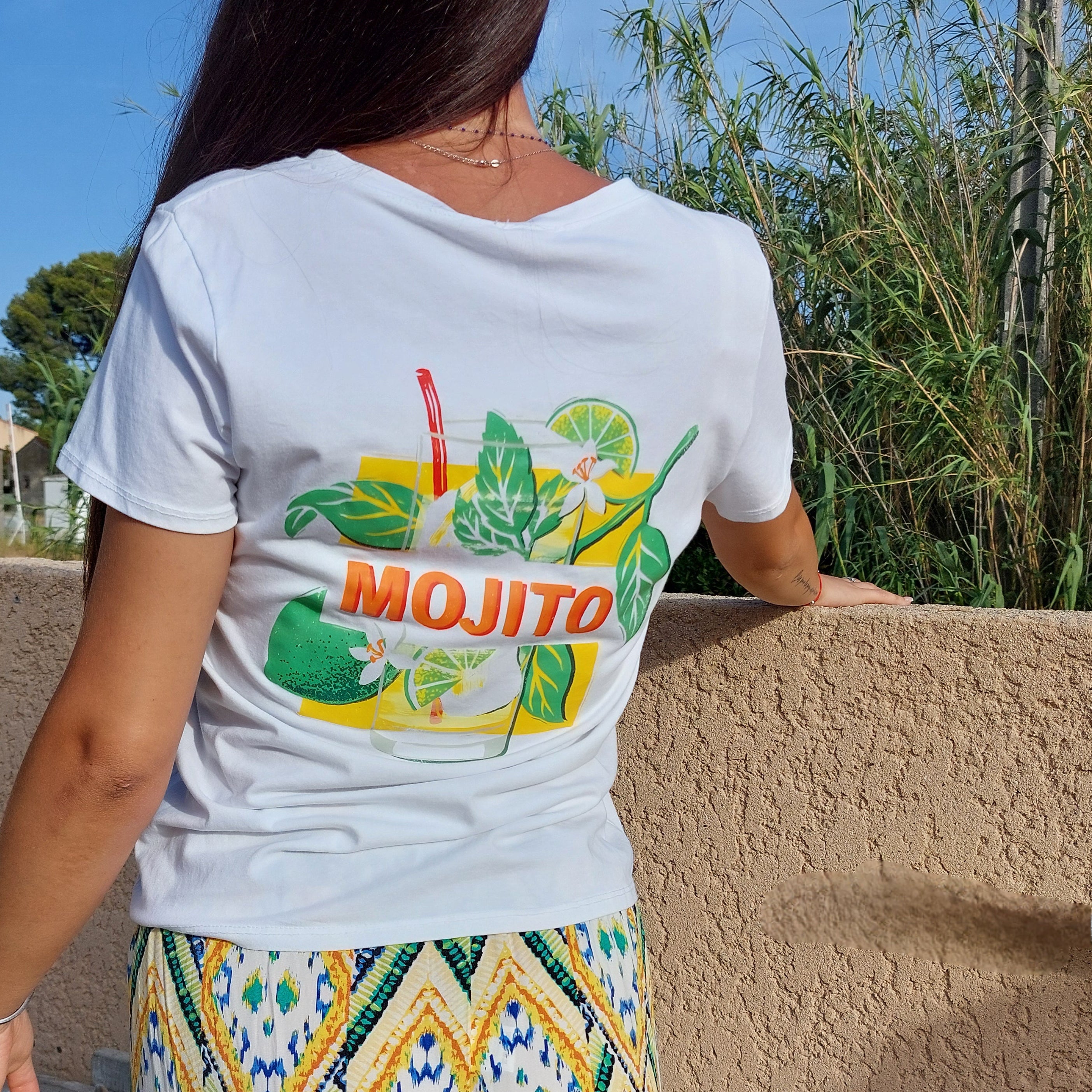 T-shirt blanc manche courte vu de dos avec motif représentant un cocktail de boisson il est écrit en rouge mojito