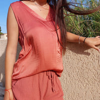 Top sans manches forme débardeur coloris terracotta satiné sur l’avant en col V et ample porté par une jeune femme 