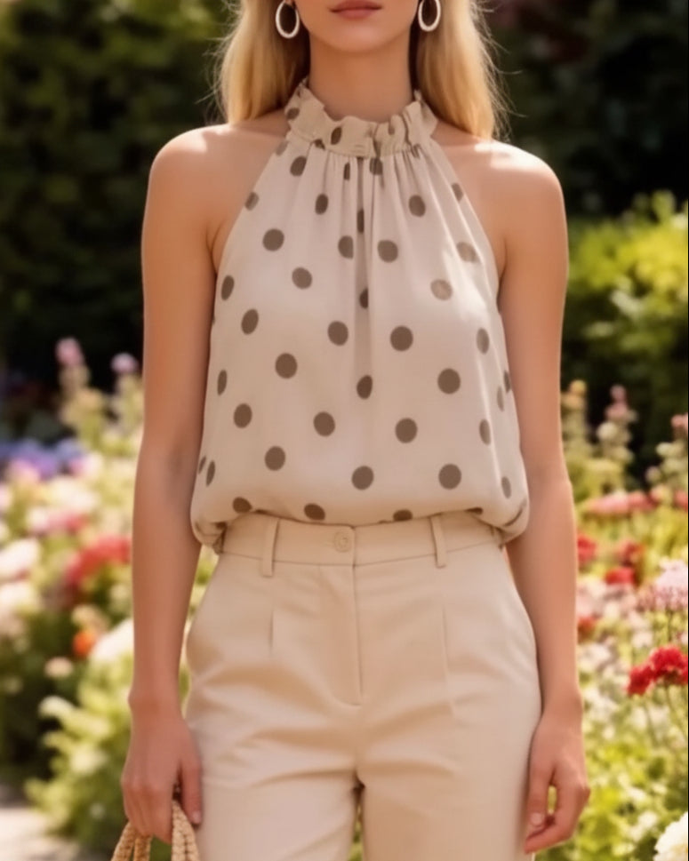 Top trapèze Charles beige à pois taupe porté de face – col halter froncé noué, coupe ample sans manches, voile doublé, pantalon beige taille haute
