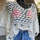 Top en crochet blanc ajouré motif rsace sur le bas et damier au dessus de la poitrine. les manches sont de formes evasées sur et 3/4. il est porté sur une jupe en jean et un haut de maillot de bain doré qui donne  une jolie transparence . musthave et look boheme sur carry le rouet