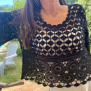 Top en crochet noir ajouré motif rsace sur le bas et damier au dessus de la poitrine. les manches sont de formes evasées sur et 3/4. il est porté sur une robe blanche à bretelle ce qui donne une jolie transparence . musthave et look boheme sur carry le rouet