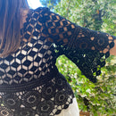 detail sur la manche 3/4 colombine du Top en crochet noir ajouré motif rsace sur le bas et damier au dessus de la poitrine. musthave et look boheme sur aix en provence