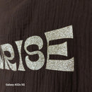 Détail inscription "Sunrise to Sunset" en lettres dorées pailletées sur le Top Sola choco — tissu texturé gaufré — ineva

