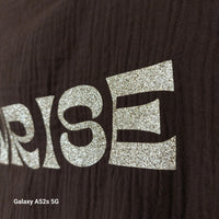 Détail inscription "Sunrise to Sunset" en lettres dorées pailletées sur le Top Sola choco — tissu texturé gaufré — ineva
