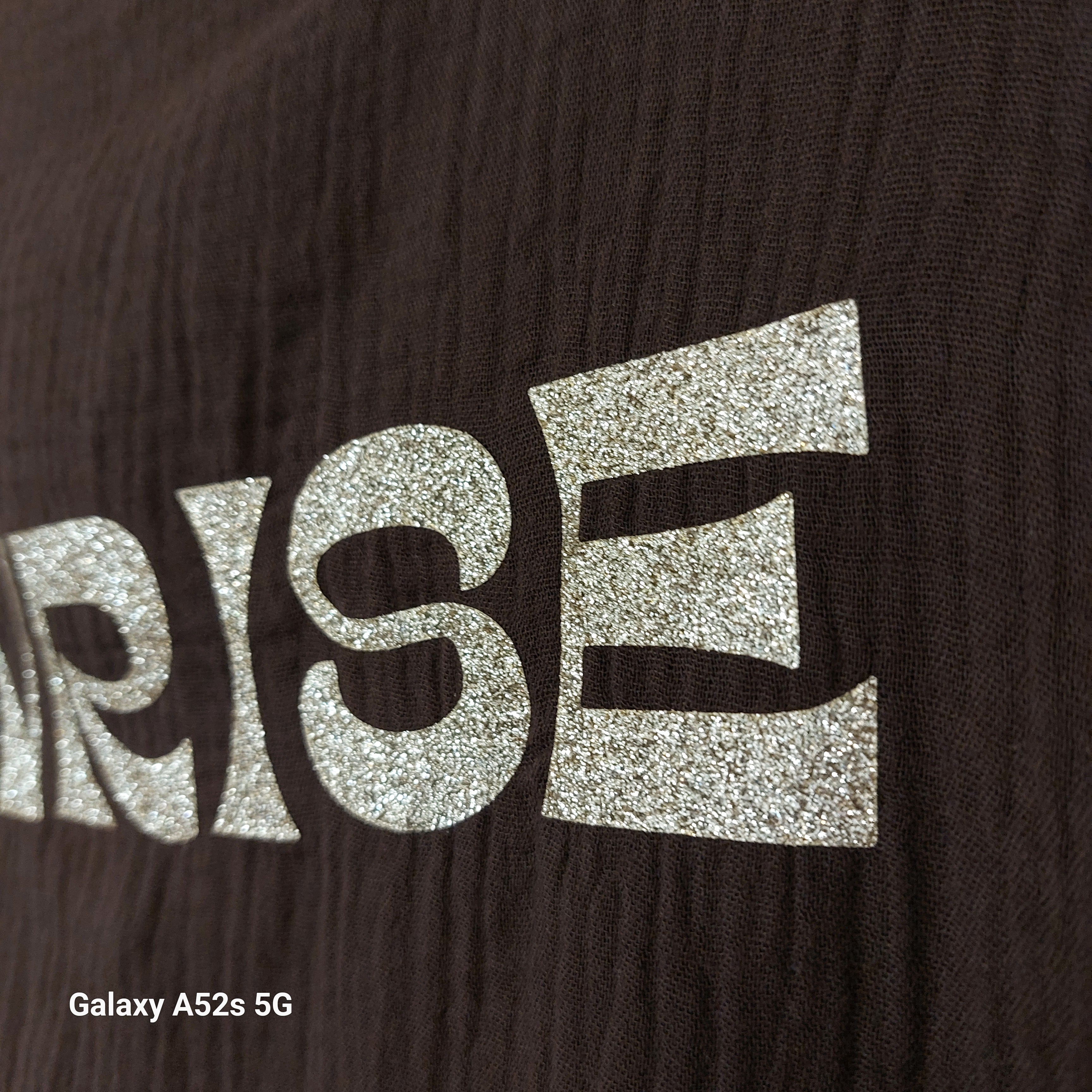 Détail inscription "Sunrise to Sunset" en lettres dorées pailletées sur le Top Sola choco — tissu texturé gaufré — ineva
