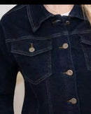 Gros plan boutons cuivres gravés Blouson Erina – détail poches poitrine boutonnantes, denim brut indigo foncé texture tissage serré
