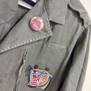 veritable veste mlitaire unie kaki. elle est customizée avec un patch tete de tigre en couleur sur poitrine gauche, elle a un badge rond sur le revers gauche du col representant un groupe de metal    sur carry le rouet