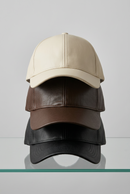 Casquettes Oz en simili cuir crème, choco et noir, superposées et vues de face
