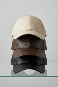 Casquettes Oz en simili cuir crème, choco et noir, superposées et vues de face
