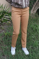 Pantalon city slim Cristiano camel porté face – coupe mi-haute stretch, revers bas, passants ceinture, associé à une blouse python et sneakers blanches
