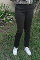 Pantalon city slim Cristiano noir porté face – coupe mi-haute stretch, revers bas, associé à une blouse python et sneakers blanches
