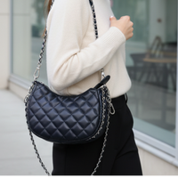 Femme portant le Femme portant le sac à main Ifrane noir matelassé - forme demi-lune et style rock chic élégant
 matelassé - forme demi-lune et style rock chic élégant
